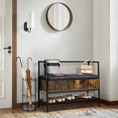 a wooden bench sitting in front of a mirror next to a wall mounted coat rack