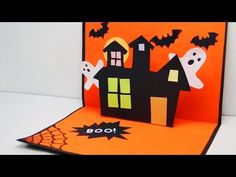 a pop up halloween card with ghost houses and bats