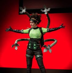 a woman dressed in black and green holding scissors