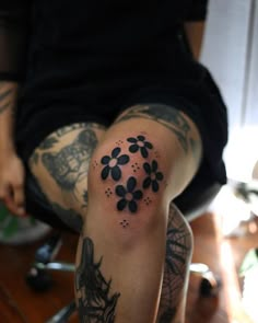 a person with tattoos on their legs and one leg is covered in black ink flowers