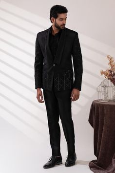 Black double lapel collar tuxedo with sequin and cutdana embroidery. Paired with a black shirt and pant.
Components: 3
Pattern: Embroidered
Type Of Work: Sequin, Cutdana
Neckline: Lapel collar
Sleeve Type: Long
Fabric: Terriwool and Cotton, Lining: Poly
Color: Black
Other Details: 
Attached poly lining
Approx. product weight: 3 kgs
Occasion: Cocktail and Reception - Aza Fashions Black Shawl Collar Blazer For Party, Black Shawl Collar Party Blazer, Winter Party Sets With Suit Collar, Luxury Winter Party Tuxedo, Tailored Party Wear Sets For Semi-formal Occasions, Tailored Festive Blazer, Fitted Party Blazer With Shawl Collar, Fitted Shawl Collar Party Blazer, Tailored Sets For Semi-formal Party Wear