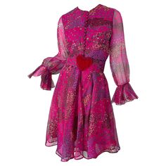 Perfect for Valentines Day! Chic 1960s OSCAR DE LA RENTA museum held pink flower and heart print long sleeve silk dress ! Features vibrant colors of purple, burgundy, green, red and pink throughout. Original detachable belt with a large red heart lucite buckle. Tailored bodice with 12 fabric covered buttons up the front, and a forgiving flattering skirt. Semi sheer sleeves with bell ruffle sleeves. Can easily be worn for any day or evening event. Pair with sandals, wedges or flats for day, and h Retro Pink Silk Dress, Pink Silk Retro Dress, Pink Retro Silk Dress, 1970s Pink Long Sleeve Dress, Long Sleeve Silk Dress, 1920 Fashion, Purple Burgundy, Silk Cocktail Dress, Oscar Dresses