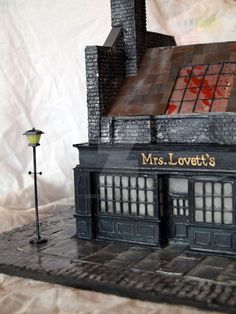 a small model of a building with a lamp on the side and a sign that says mrs lovet's