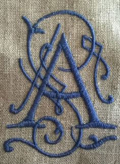 an embroidered monogram on a piece of cloth with the letter a in the middle