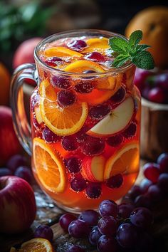 a pitcher filled with liquid surrounded by fruit