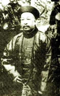 an old black and white photo of a man standing in front of some trees with his hands on his hips