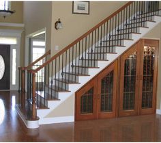 a staircase leading to the second floor in a house with wood floors and glass doors