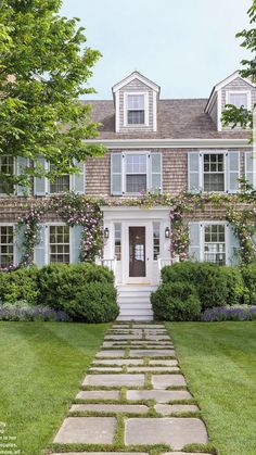 a large brick house with white trim and blue shutters is featured in the front cover of this magazine