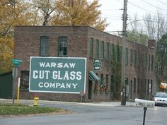 a sign that says warsaw cut glass company on the side of a brick building