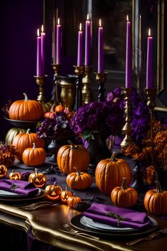 a table topped with lots of purple and orange pumpkins next to tall candlesticks