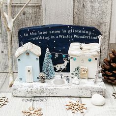 there is a small wooden house with snow on the roof and decorations around it in front of a sign that says, in the lane snow is glistening walking in winter wonderland