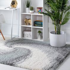 a living room with a white book shelf and potted plant