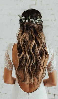 the back of a woman's head with long hair and flowers in her hair