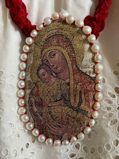 Madonna with the Christ child, an oval brocade necklace, bordered with cultured pearls in white.  Smaller one (10cm high) bordered with white, pink, beige pearls.  One of the Madonnas is is embellished with old Czech gilded beads.  The necklace is hung on a 51cm long cotton cord, finished with a stainless steel clasp. Cultured Pearls, Madonna, Fiber Art, Jewelry Necklace Pendant, Birthday Gifts, Accessory Gift, Beads, Electronic Accessories, Paper Party Supplies