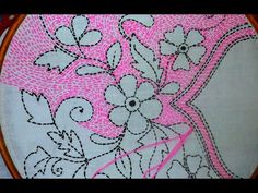 a close up of a pink and white embroidery