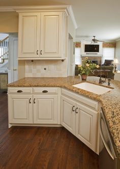 a kitchen with white cabinets and granite counter tops