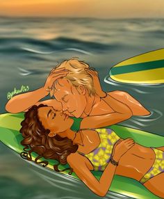 a woman laying on top of a surfboard next to a man in the ocean