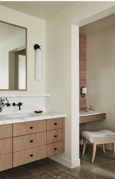 a bathroom with two sinks and a large mirror above the sink, along with a stool