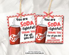 two soda signs with red and white checkered ribbon hanging from twine on top of each other