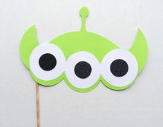 a green cupcake topper with googly eyes and a toothpick sticking out of it