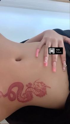 a woman with pink nail polish laying on her stomach and holding onto the side of her body