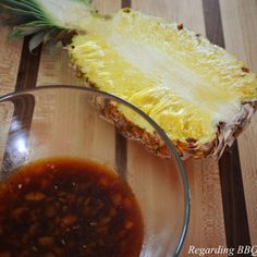 a pineapple sitting on top of a wooden table next to a bowl of food