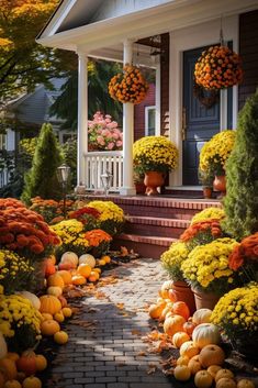 a house with lots of pumpkins and flowers on the front porch