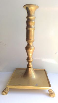 a gold colored candle holder on a white surface