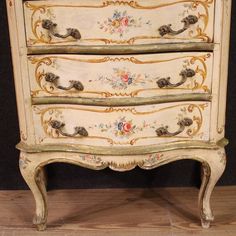 an ornate painted chest of drawers on display