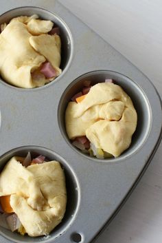 four muffin tins filled with food sitting on top of a table next to a cupcake pan