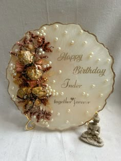 a happy birthday card with chocolates and pearls on the plate next to a figurine