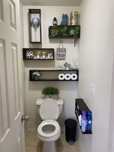 a white toilet sitting in a bathroom next to a shelf filled with bottles and other items