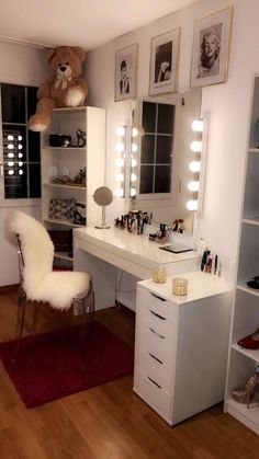 there is a vanity with lights and a teddy bear