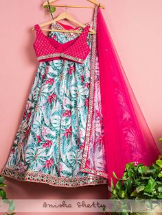 A three-piece Tropical Print Mirror Lehenga set from the Anisha Shetty collection. This beautiful hot pink blouse in net fabric is paired with a tropical print satin lehenga. The hot pink color with sequence embroidery and mirror lace enhance this lehenga set. The outfit is completed with a mirror lace net pink dupatta. Mirror Lehenga, Border Mirror, Print Mirror, New Lehenga, Hot Pink Blouse, Satin Lehenga, Dupatta Border, Hot Pink Blouses, Mirror Work Blouse