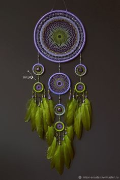 a purple and green dream catcher hanging from a wall