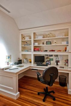 a home office with built - in shelving, desk and chair is seen here