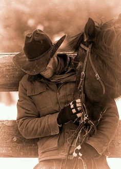 a person sitting on a bench next to a horse wearing a cowboy hat and jacket