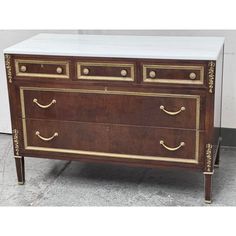 an antique chest of drawers with marble top and brass trimmings on the front