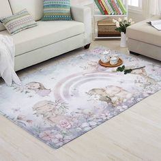 a living room with white furniture and flowers on the floor, including a rug that has an elephant design