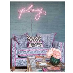 a living room filled with furniture and a neon sign on the wall above it's headboard