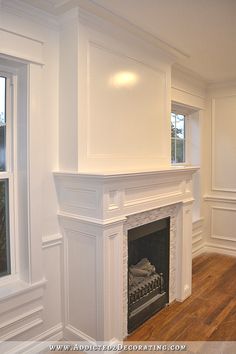 an empty living room with a fireplace and white paint on the walls, hardwood floors