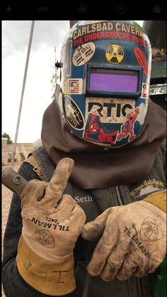 a person wearing gloves and a helmet with writing on it