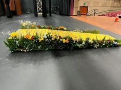 an arrangement of flowers and grass on a stage