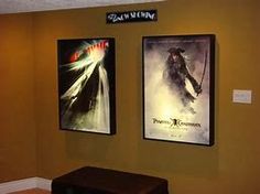 two movie posters hang on the wall above a bench in front of a yellow wall