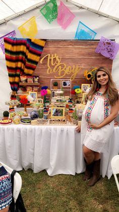 a pregnant woman standing in front of a table