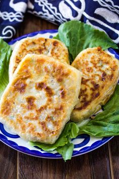 some food is on a blue and white plate with lettuce leaves around it