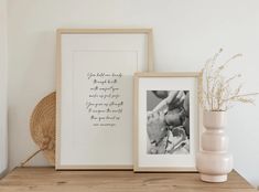 two framed pictures and a vase on a shelf