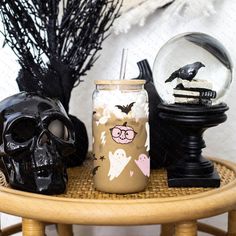 halloween decorations on a table with a skull and glass ball in the middle, next to a candle holder