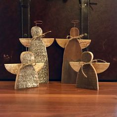 three wooden angel figurines sitting on top of a table