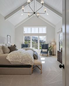 a large bed sitting in a bedroom next to a window with lots of light on it